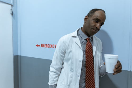 Doctor in Lab Coat Holding a Cup