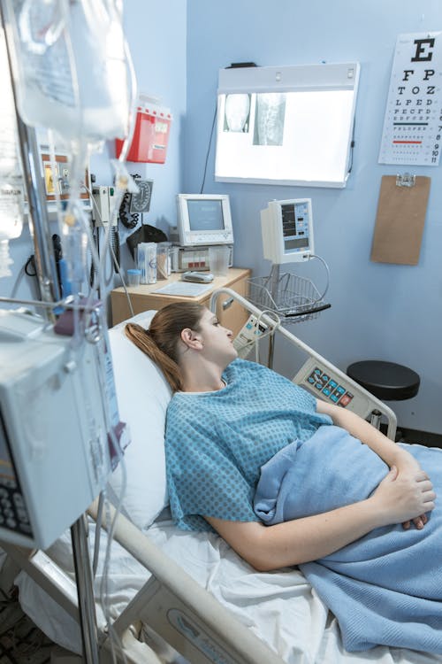 Wanita Dengan Kemeja Polka Dot Biru Dan Putih Berbaring Di Ranjang Rumah Sakit