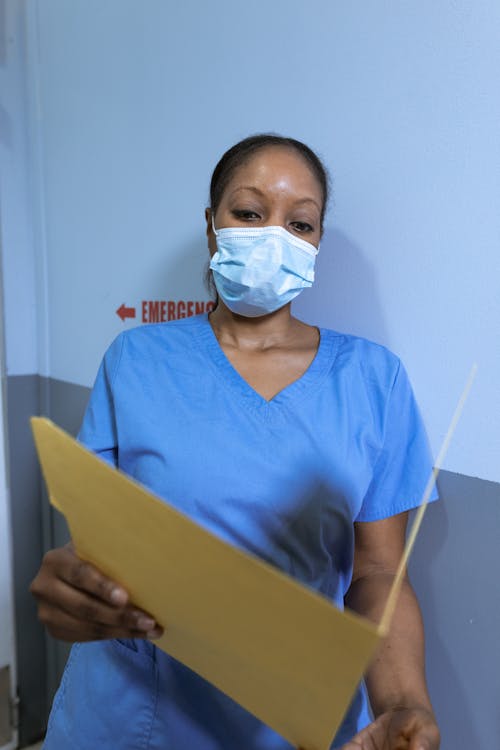 Woman Wearing a Face Mask Reading a Document