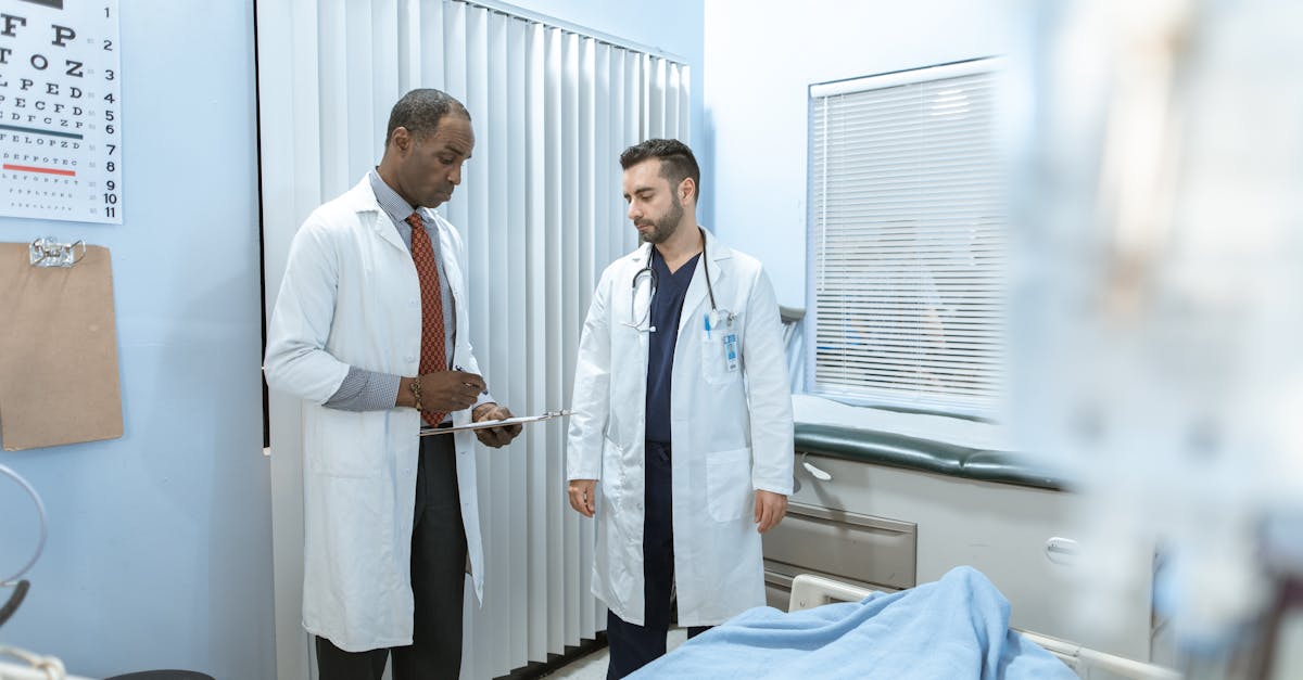 Two doctors review a patient's chart in a hospital room, focusing on healthcare cooperation and medical care. Two doctors review a patient's chart in a hospital room, focusing on healthcare cooperation and medical care.
