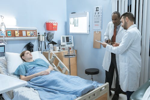 免費 藍色磨砂服坐在醫院的病床上的男人 圖庫相片
