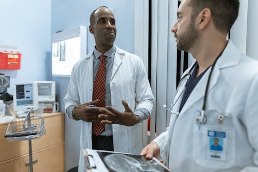 Two doctors in lab coats discussing an X-ray in a clinical setting.
