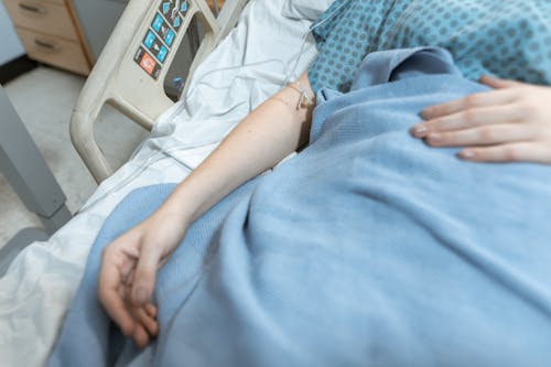 Blue Blanket on a Patient Lying on the Hospital Bed