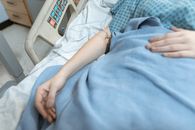 Person in White Shirt Lying on Hospital Bed