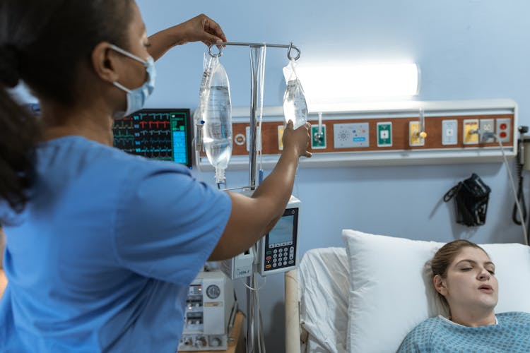 Nurse Fixing A Patient's Dextrose Bags