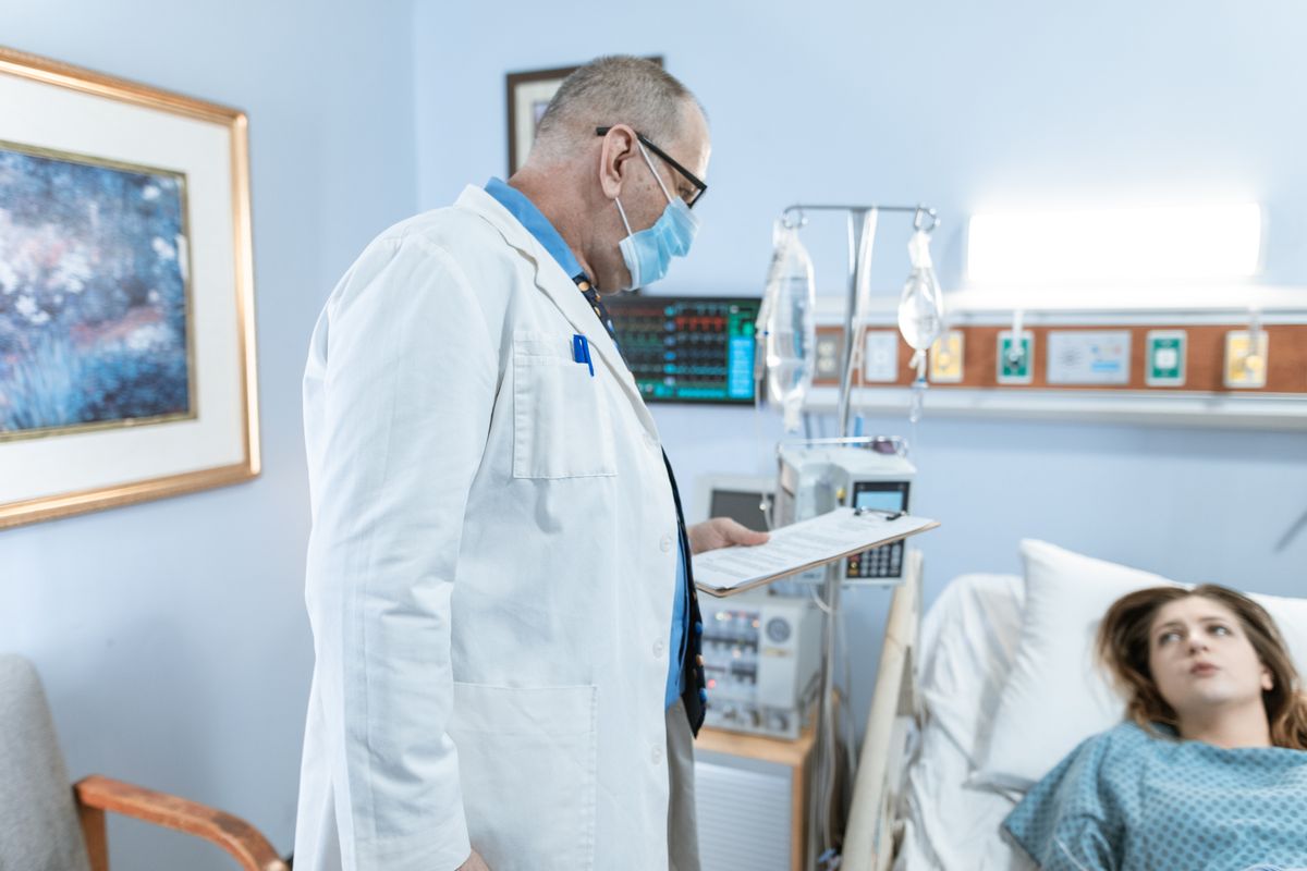 Physician in a white coat checking up on a patient