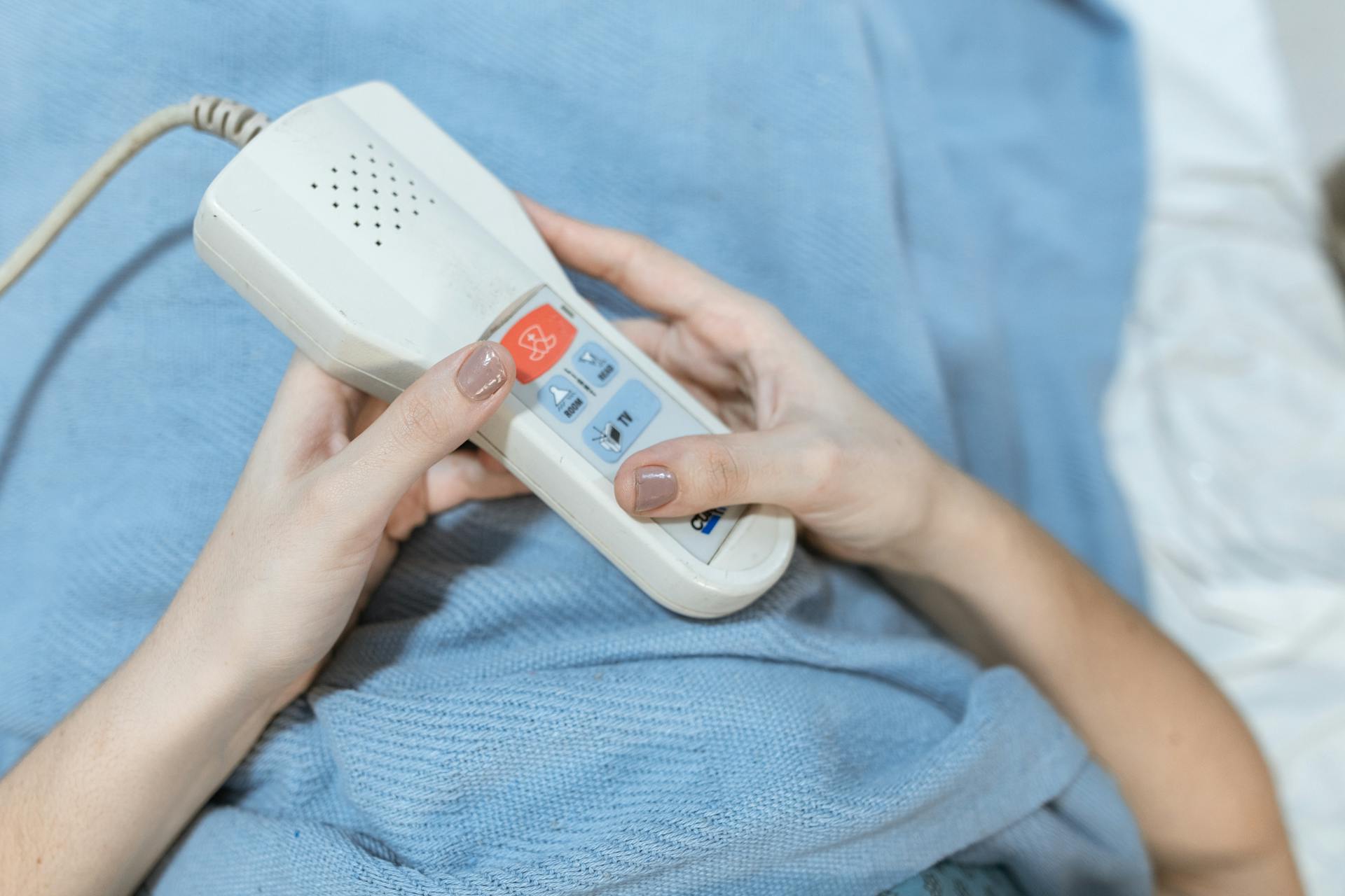 Close-Up Photo of a Person Holding a White Remote Control