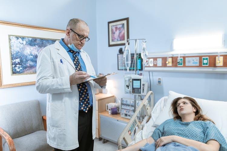 A Physician In White Coat Checking Up On His Patient