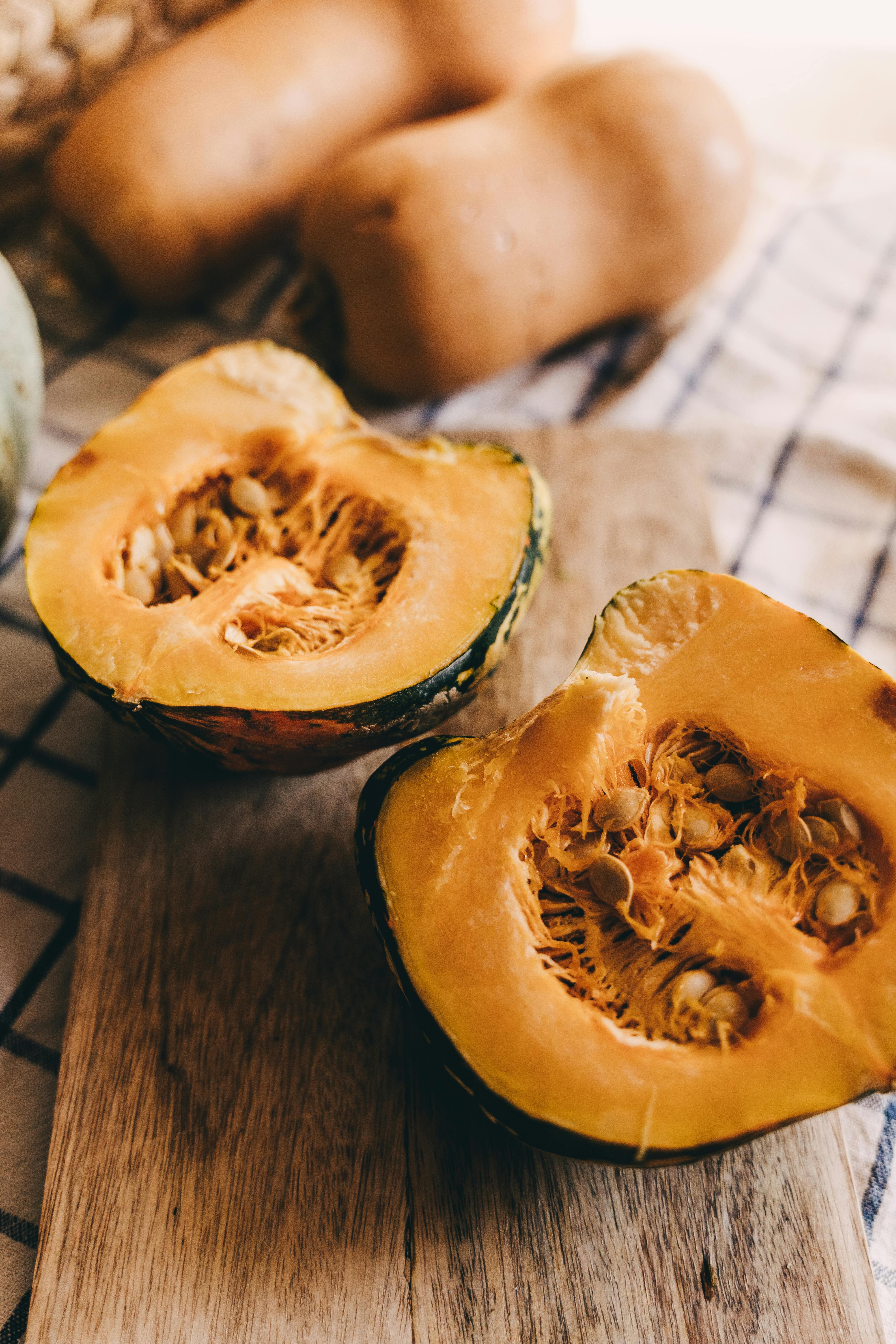 Sliced organic pumpkin on a wooden chopping board for healthy vegan cooking.