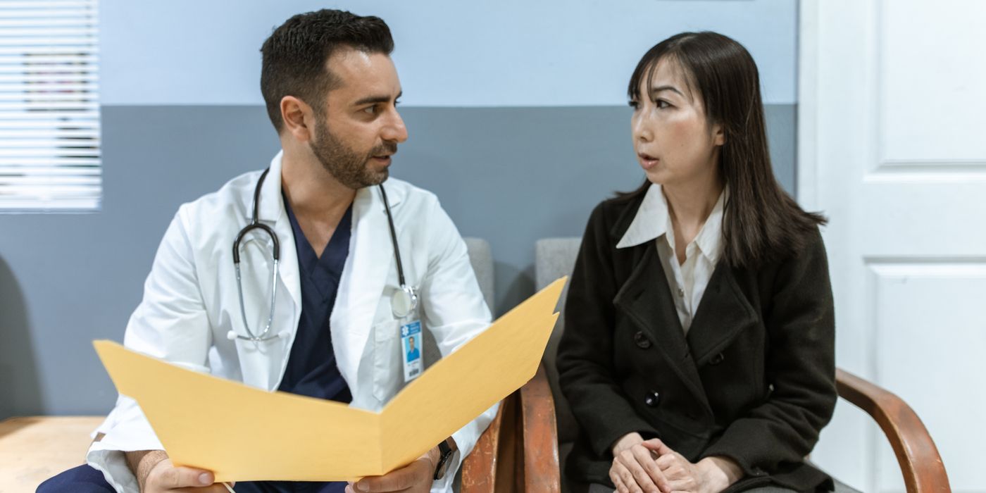 Healthcare professional consults patient in clinical setting. Medical discussion and diagnosis.