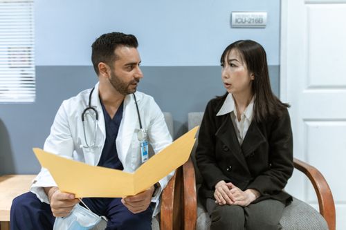 Free Healthcare professional consults patient in clinical setting. Medical discussion and diagnosis. Stock Photo