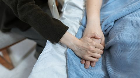 A comforting hand hold in a hospital, showcasing support and care.