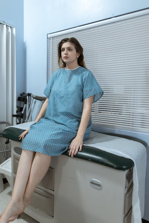 Free Female Patient sitting on a Doctor's Examination Table Stock Photo