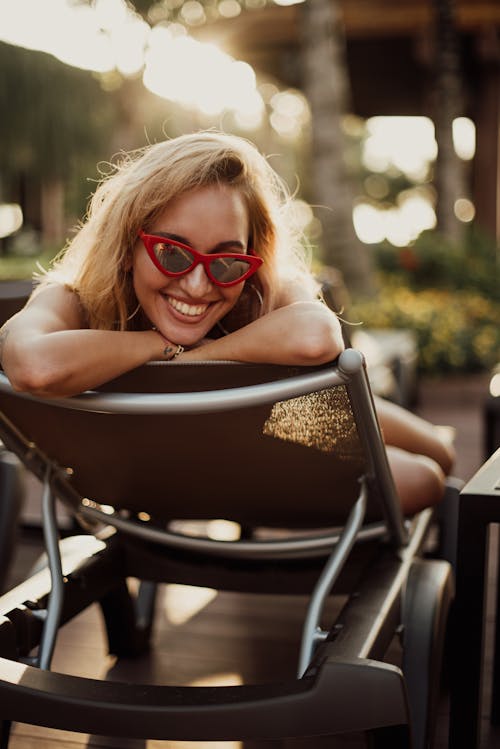 Close-up Photo of a Happy Woman wearing Red Sunglasses
