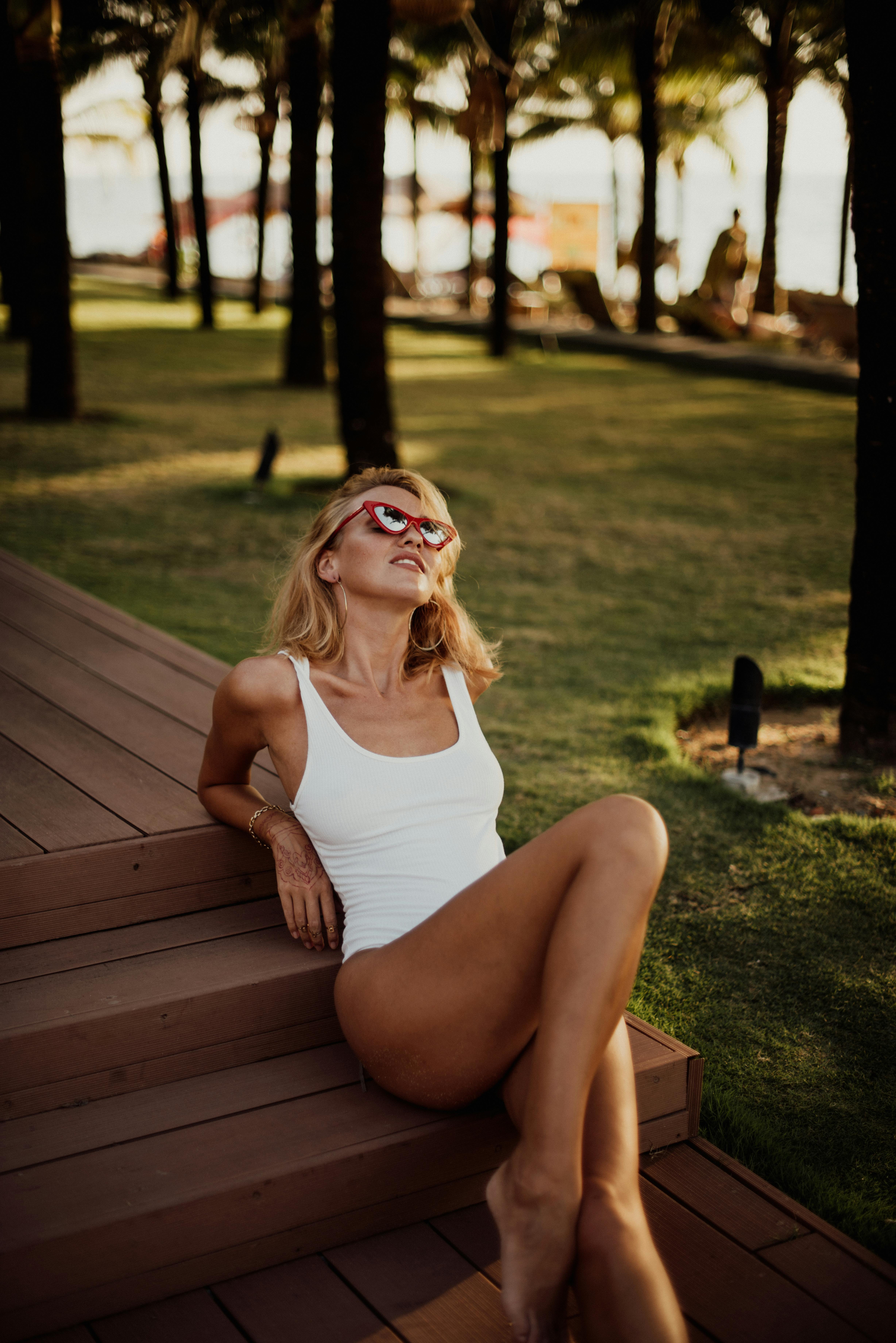 戴着太阳镜、穿着泳衣的女子在巴厘岛的一个热带度假胜地享受阳光明媚的一天