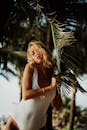 巴厘岛，一名金发女子与棕榈叶合影，散发着热带气息