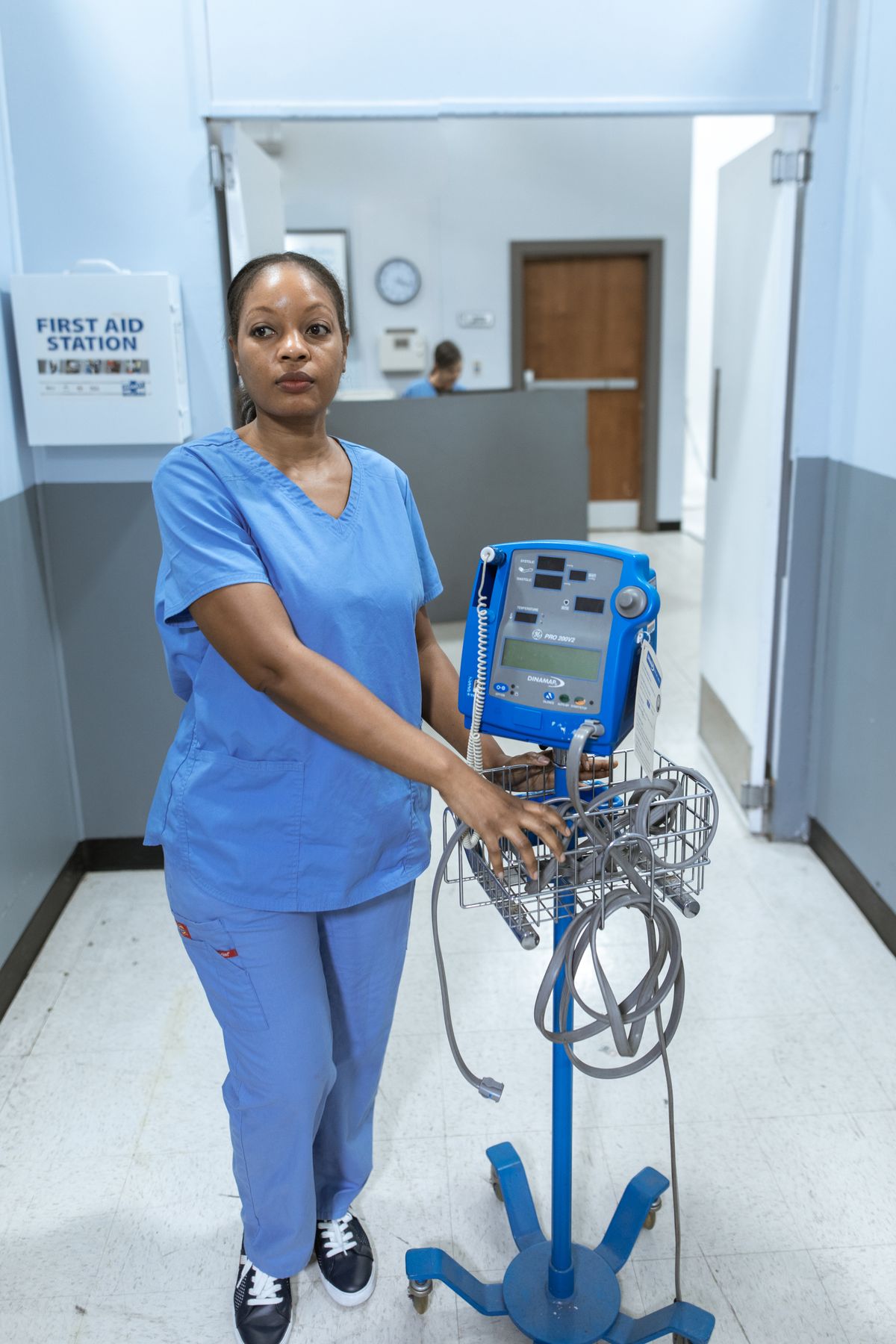 Nurse in blue scrubs resting between long shifts in supportive plus-size compression socks