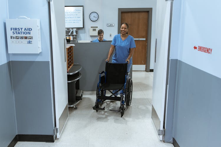 Female Nurse Pushing A Wheelchair 