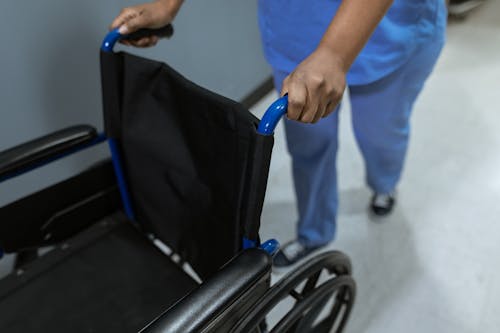 Free High Angle Shot of Medical Practitioner pushing a Wheelchair  Stock Photo