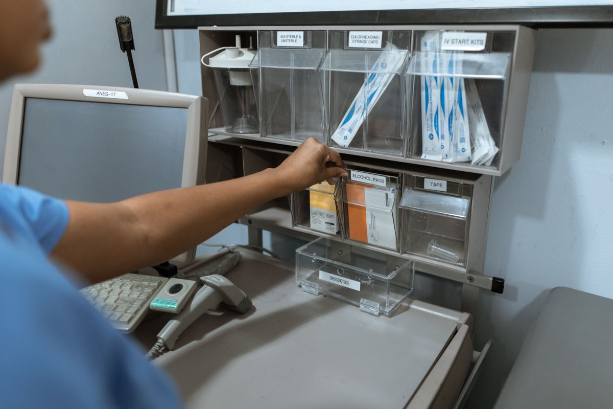 Healthcare worker organising medical supplies in a clinical storage station