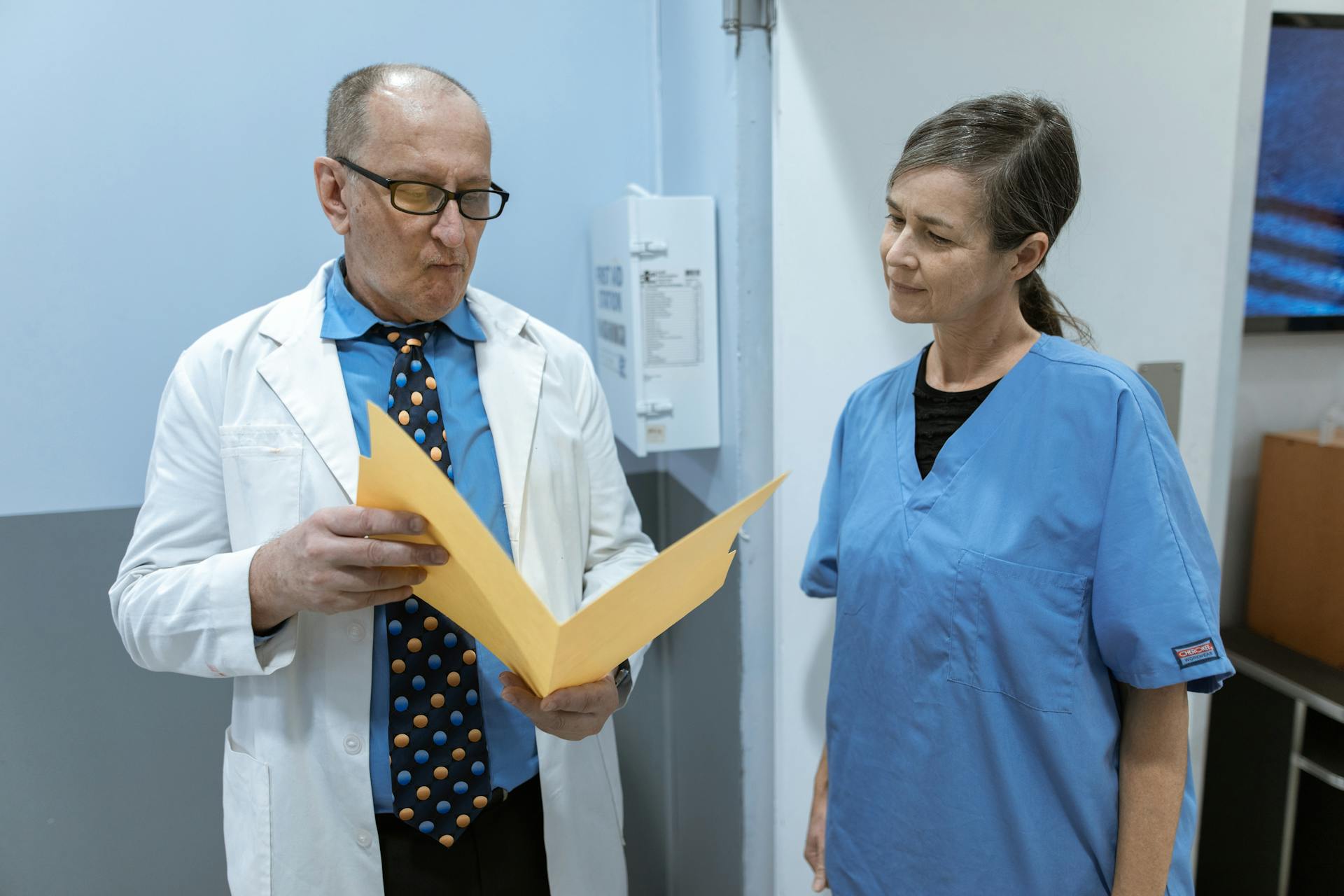 Doctors and nurses in consultation over patient records within a hospital setting.