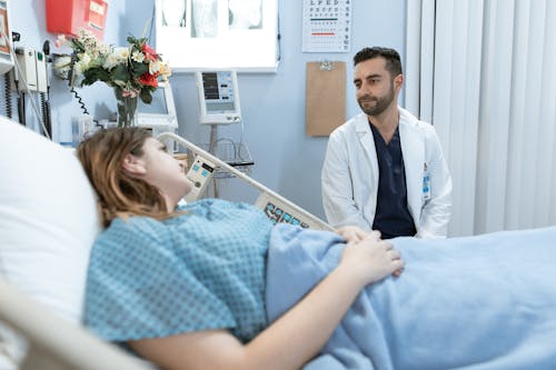 Uomo In Camicia Bianca Abbottonata Seduto Accanto A Donna In Abito A Scacchi Bianco E Blu