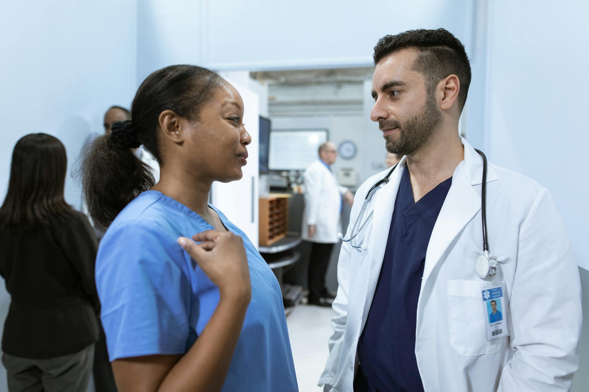 Medical professionals discussing patient care in a hospital hallway.