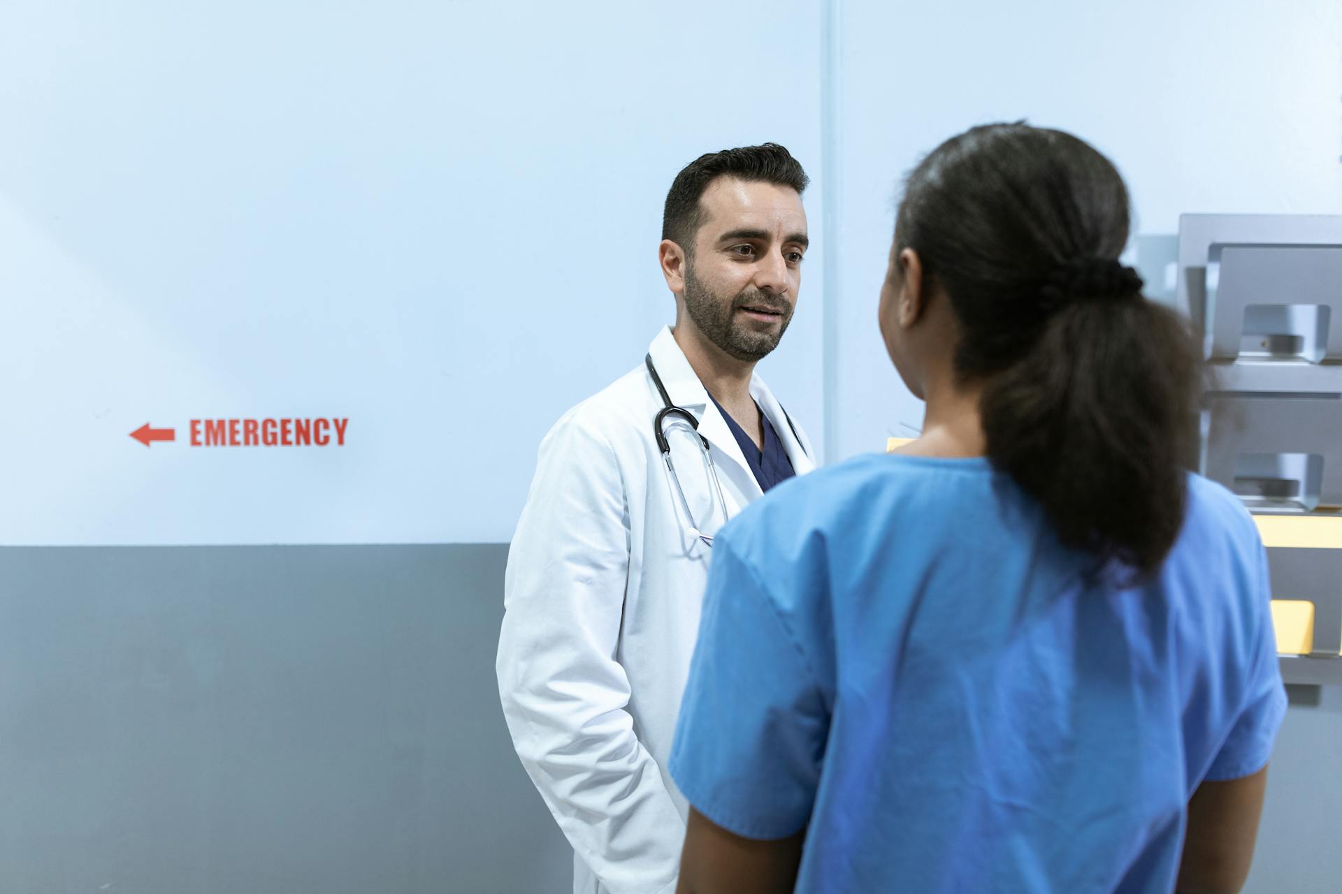 Doctors and nurses conversing near emergency room in a hospital setting.