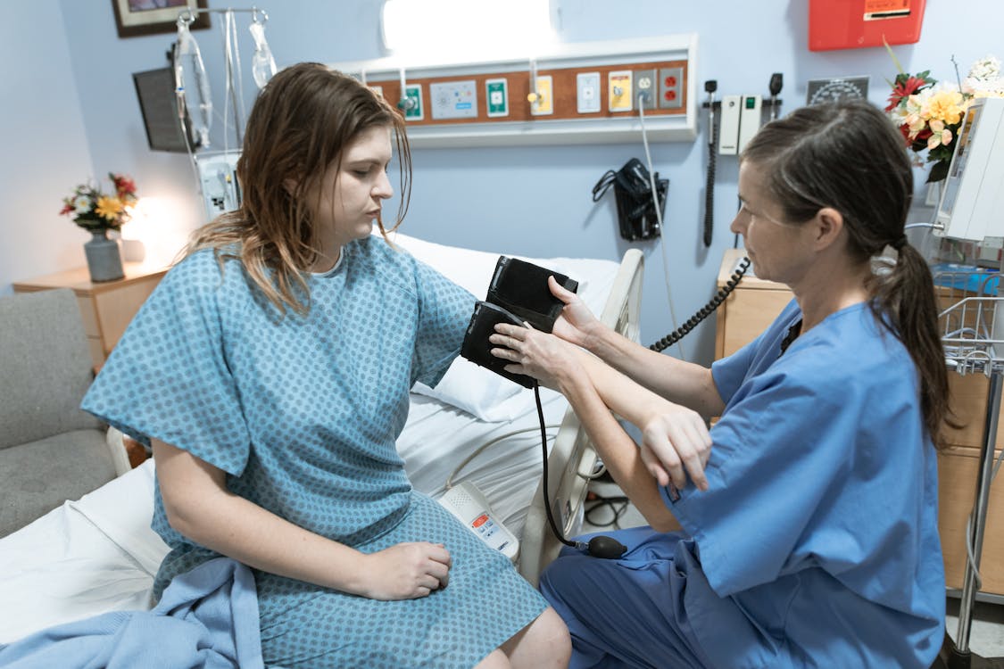 Free Nurse Taking the Blood Pressure of a Patient Stock Photo