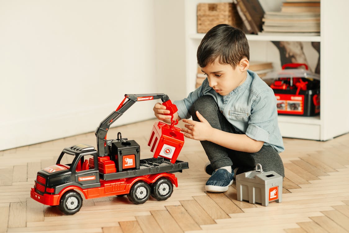 Boy in Denim Shirt Playing with Crane Tractor