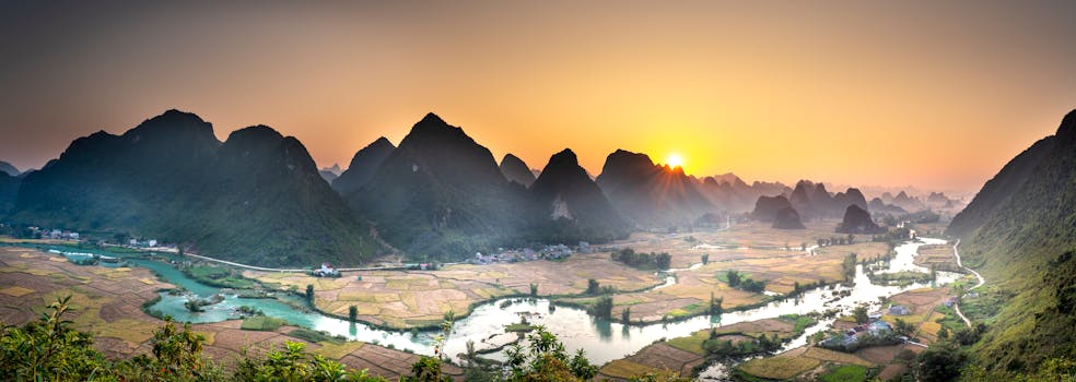 Tranquil panoramic view of mountains and fields at sunset.