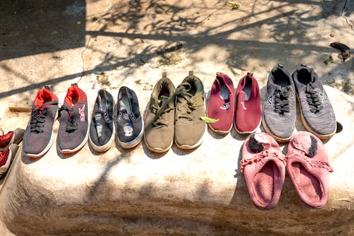 Free Various footwear for selling placed on stone on street Stock Photo