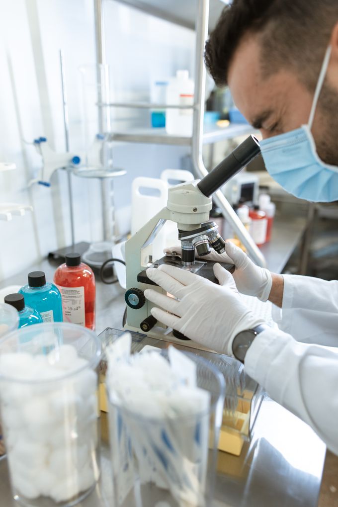 A laboratory scientist examining samples through a microscope