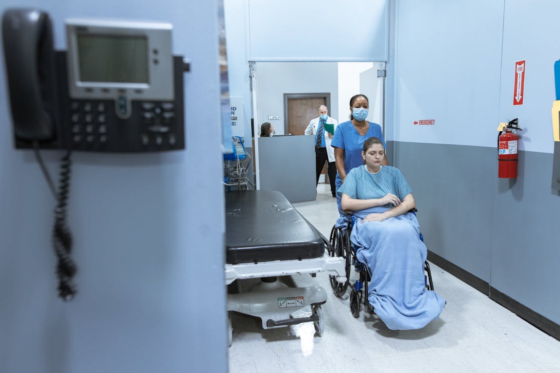 Free Nurse assisting a Patient on a Wheelchair  Stock Photo