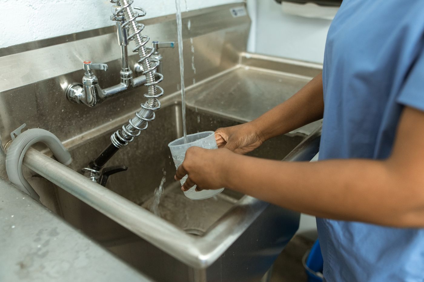 Restaurant kitchen worker sanitizing utensils and food-service equipment