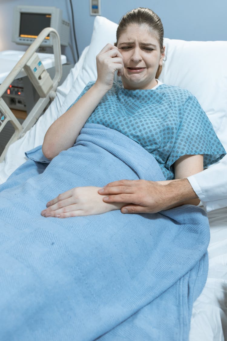 Woman Hospital Gown Lying On Bed Crying