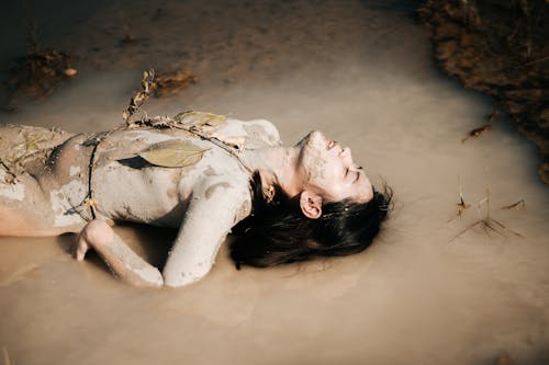 Free Seductive naked Asian woman lying in dirty pond Stock Photo