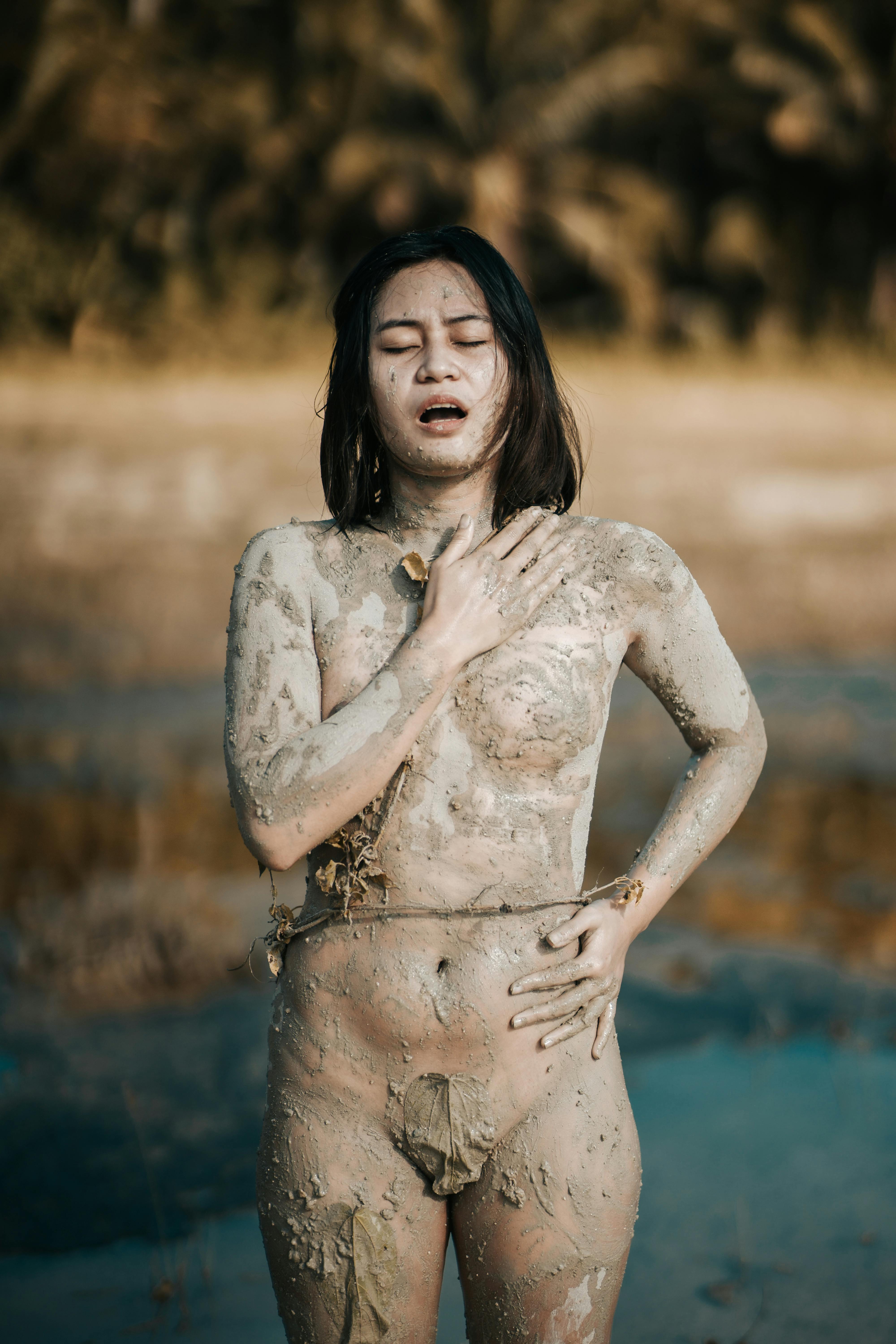 Sensual naked Asian woman touching chest near pond · Free Stock Photo photo