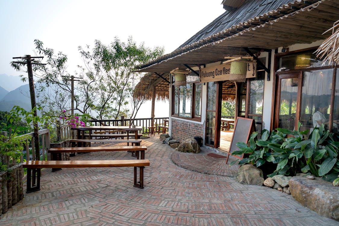 Free Exterior of small restaurant with wooden tables outside located on top of mountain in tropical terrain Stock Photo