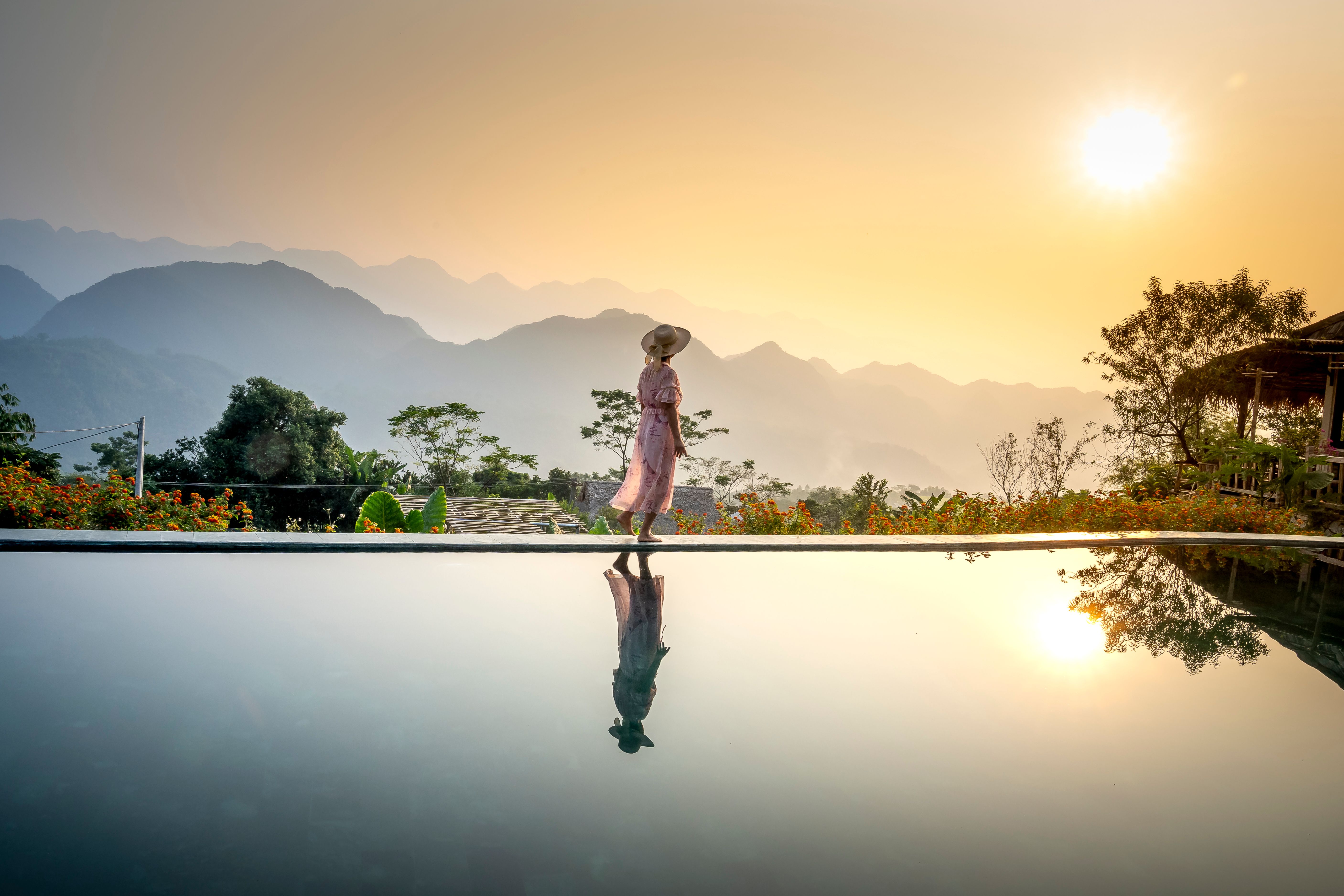 Woman walking along pool in evening · Free Stock Photo