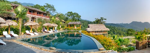 Small cozy hotel in south eastern style with swimming pool and deckchairs in tropical resort