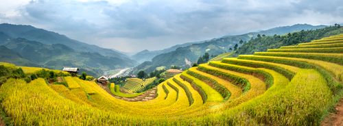 Free Picturesque scenery of terraced rice fields on slopes of mountains against cloudy sky in tropical countryside Stock Photo