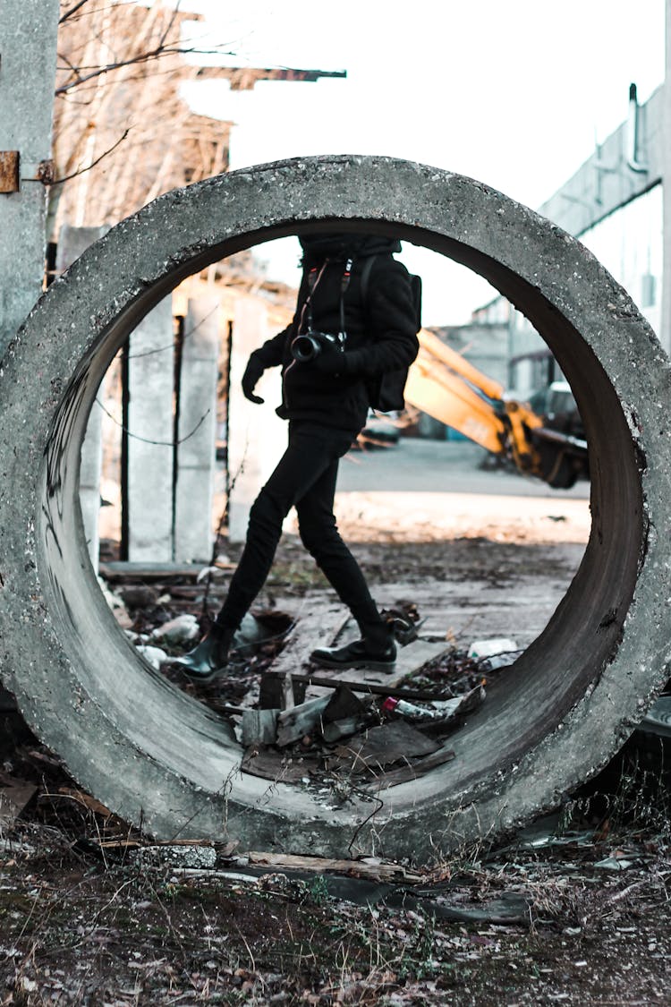 Crop Man With Photo Camera Strolling Near Concrete Ring