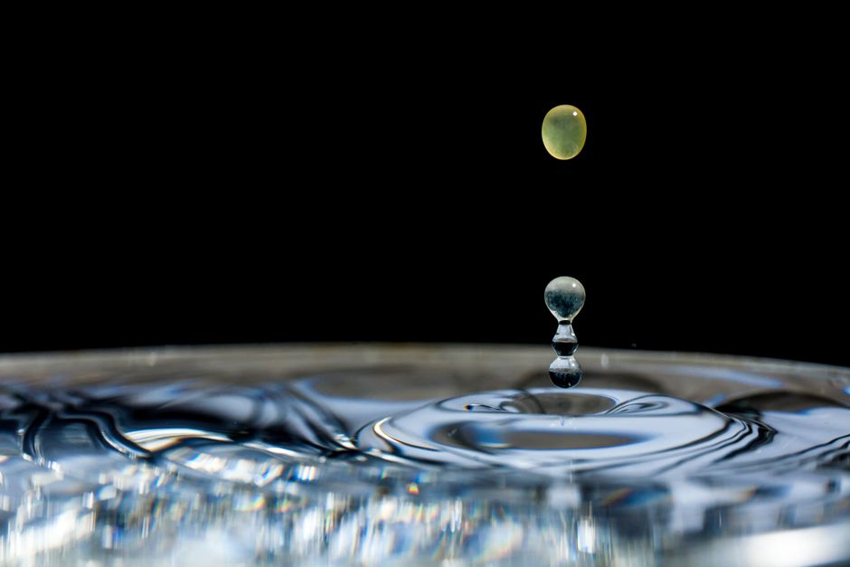 Captivating close-up of a water droplet creating ripples in a still pool.