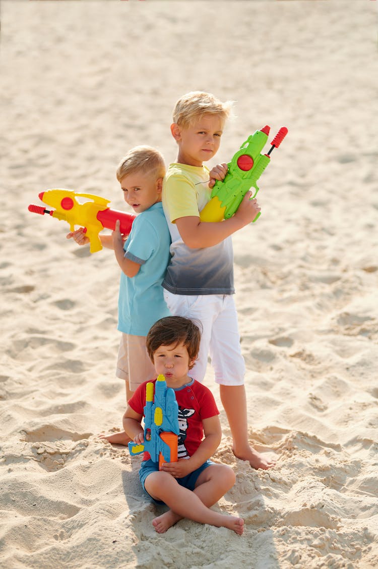  Boys Playing On Beach With Water Guns