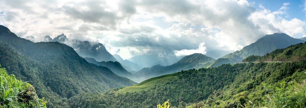 Stunning mountain landscape with lush greenery under a dramatic sky.
