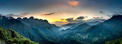Free Panoramic view of high ridges with fog and curved roadways under fluffy clouds in twilight Stock Photo