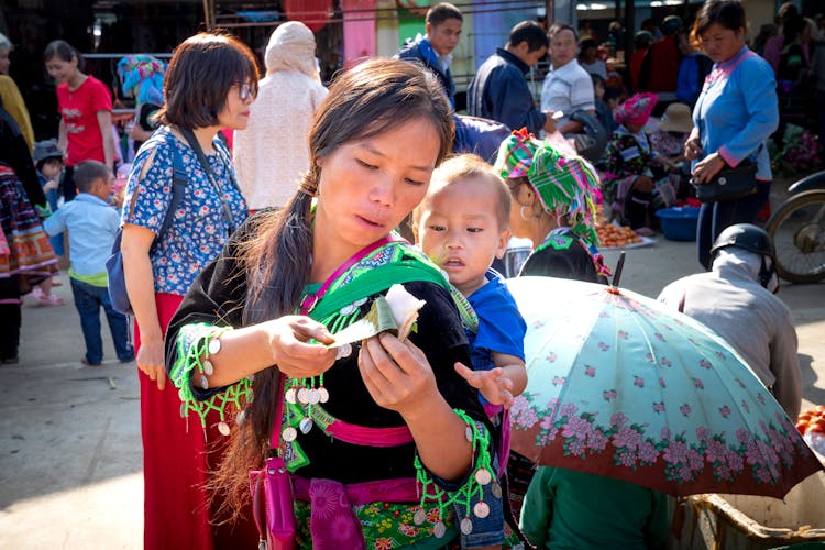 Asian Mother With Child And Sweet Rice In Banana Leaf