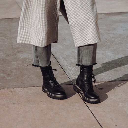 Court Prime '82 worn on a sunlit city sidewalk with a check overcoat — photo by Igor Kirillov on Pexels
