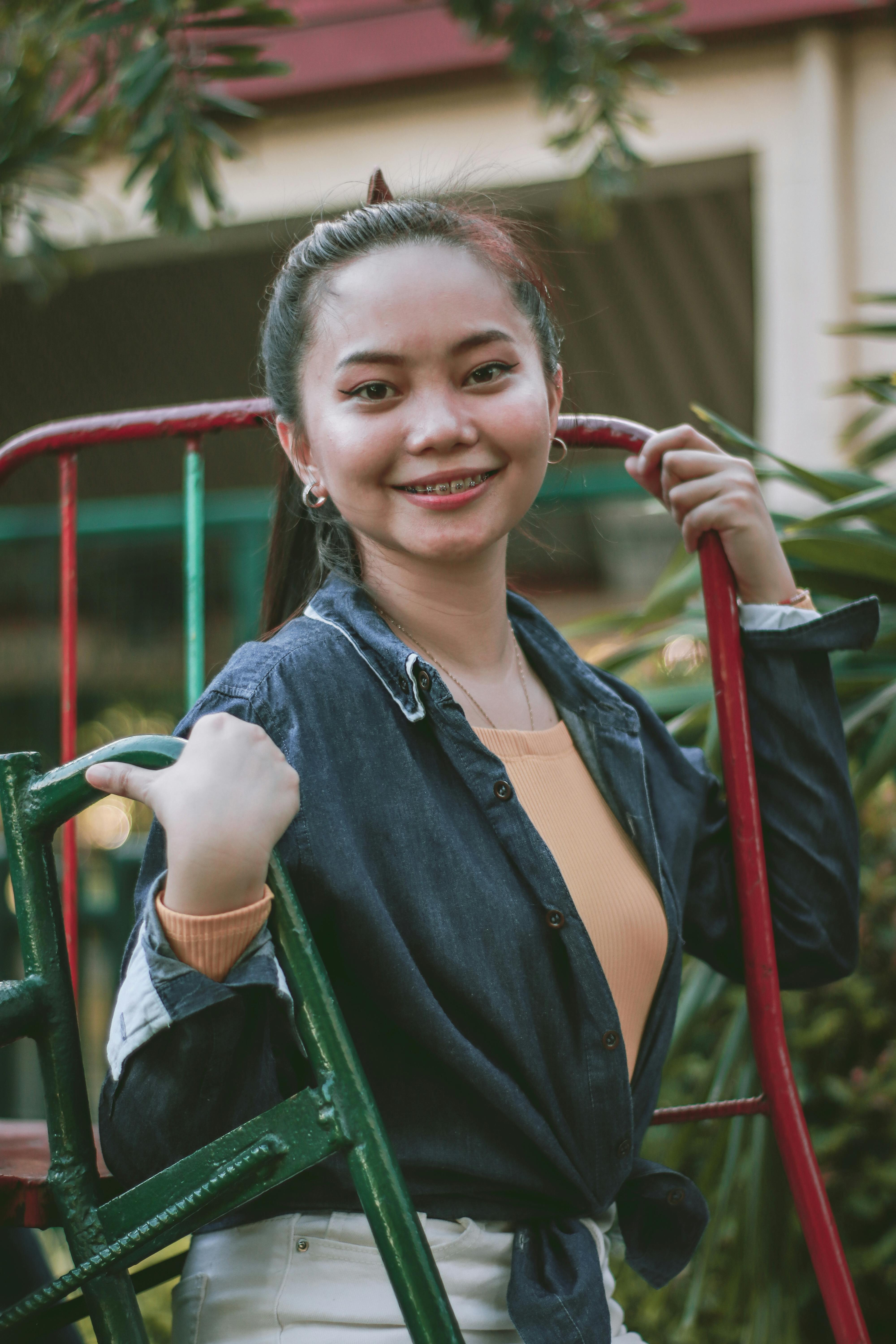 Young woman smiling in a casual outdoor setting, evoking a joyful and relaxed vibe.